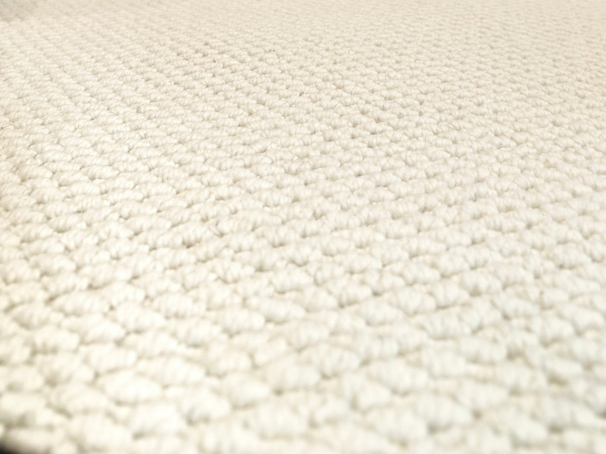 A low view across the Halcyon rug's close ivory loops.