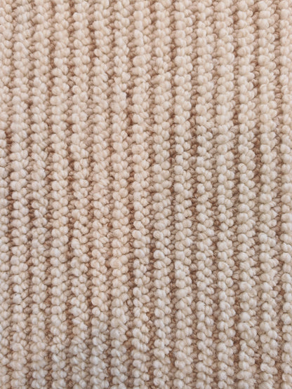 The Glint rug's ribbed surface, with rows of oatmeal loops running its length.