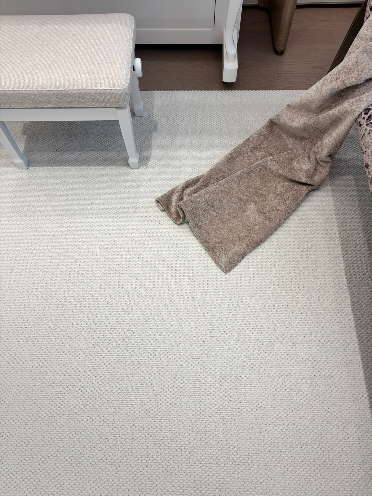 Looking down on the Halcyon rug beside a cream bench, with a throw trailing onto it.