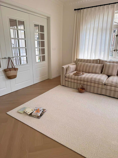 Sunlit rug in a bright living room with a striped sofa and white French doors.