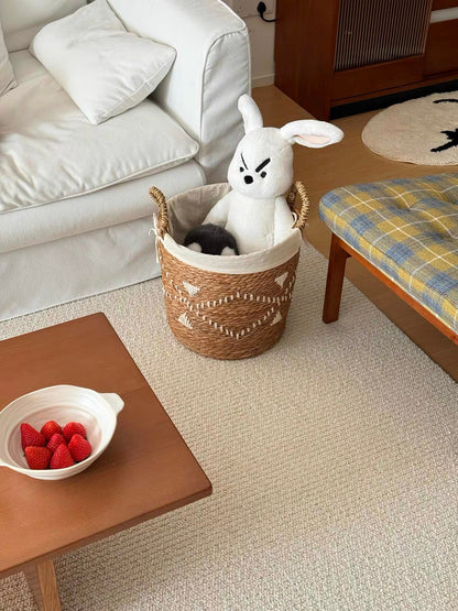 Sunlit rug beside a white sofa and a coffee table with a bowl of strawberries.