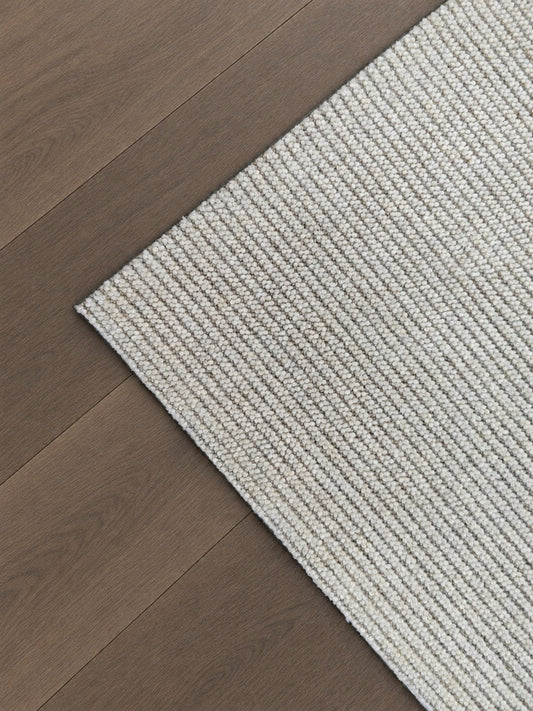 Corner of the Vesper rug on a timber floor, showing its cream and taupe corded surface.