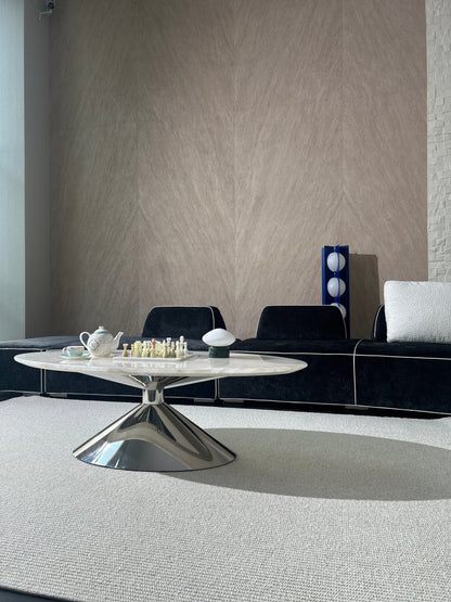 Wide view of the Vesper rug under an oval coffee table with a tea set, in front of a black sofa.